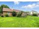 A large backyard featuring lush green grass, mature trees, and a quaint wooden deck attached to a brick house at 1106 Summer Way Ct, Shelbyville, IN 46176