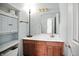 Bright bathroom with a wood vanity, decorative mirror, and storage cabinets at 1106 Summer Way Ct, Shelbyville, IN 46176