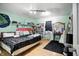 Bright bedroom with wood floors, graffiti wall art, shelves, and a vanity near a window at 1106 Summer Way Ct, Shelbyville, IN 46176