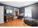 Blue bedroom featuring wood floors, a TV on a cabinet, and a small makeup table at 1106 Summer Way Ct, Shelbyville, IN 46176