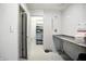 Bright laundry room featuring a utility sink, storage area, and tiled floor and walls at 1106 Summer Way Ct, Shelbyville, IN 46176