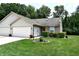 Charming home featuring a well-manicured lawn, attached garage, and lovely landscaping at 1223 Long Shore Dr, Indianapolis, IN 46217