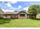 Backyard view of a brick home featuring a well-maintained lawn and a wooden deck at 1237 Driftwood Dr, Carmel, IN 46033