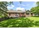 Beautifully landscaped backyard with a brick home, wooden deck, and a well-manicured lawn perfect for outdoor activities at 1237 Driftwood Dr, Carmel, IN 46033