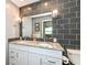 Modern bathroom with double granite sinks and dark tiled walls at 1237 Driftwood Dr, Carmel, IN 46033