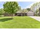 Charming brick home with a well-manicured lawn, mature trees, and a welcoming driveway leading to an attached garage at 1237 Driftwood Dr, Carmel, IN 46033