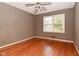 A gray bedroom with a ceiling fan and a large window providing natural light at 136 W Loretta Dr, Indianapolis, IN 46217