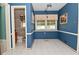 The dining room boasts blue painted walls, white tiled floors, and a modern track lighting fixture at 136 W Loretta Dr, Indianapolis, IN 46217