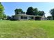 Well-maintained home with lush front lawn, mature trees, and attached two-car garage at 136 W Loretta Dr, Indianapolis, IN 46217