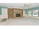 This living room boasts a stone fireplace, a ceiling fan, and large windows at 136 W Loretta Dr, Indianapolis, IN 46217