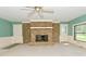 This living room features a stone fireplace, a ceiling fan, and views to the backyard at 136 W Loretta Dr, Indianapolis, IN 46217
