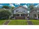 Charming two-story home featuring a covered front porch with brick accents and a well-maintained lawn at 1427 N Lasalle St # 1427, Indianapolis, IN 46201