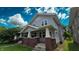 Inviting two-story home with a classic front porch and lush greenery, offering a blend of comfort and style at 1427 N Lasalle St # 1427, Indianapolis, IN 46201