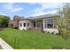 Expansive backyard featuring a modern white brick home with a covered patio and lush green lawn at 16512 Grand Cypress Dr, Noblesville, IN 46060