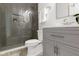 Bathroom featuring a gray vanity, toilet, and glass-enclosed shower with herringbone tile at 16512 Grand Cypress Dr, Noblesville, IN 46060