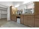 Bright bathroom features dual sinks, wooden cabinets, large mirror, and a walk-in closet for ample storage at 16512 Grand Cypress Dr, Noblesville, IN 46060