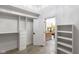 Spacious walk-in closet with custom shelving and organization systems, and a view to a bathroom vanity at 16512 Grand Cypress Dr, Noblesville, IN 46060