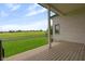 Inviting covered patio offering serene views of the expansive green field and blue sky at 16512 Grand Cypress Dr, Noblesville, IN 46060