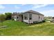 Stunning backyard view of the home featuring a large green lawn, well-maintained landscaping, and a patio area at 16512 Grand Cypress Dr, Noblesville, IN 46060