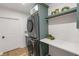 Laundry area with modern washer and dryer, folding counter, and storage shelving at 16512 Grand Cypress Dr, Noblesville, IN 46060