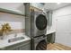 Updated laundry area featuring stacked washer and dryer and built-in utility sink at 16512 Grand Cypress Dr, Noblesville, IN 46060