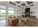Open living room with modern fireplace, hardwood floors, sleek furniture, and oversized windows with scenic views at 16512 Grand Cypress Dr, Noblesville, IN 46060