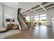 Bright living room boasting a staircase, hardwood floors, large windows offering scenic views, and stylish furniture at 16512 Grand Cypress Dr, Noblesville, IN 46060
