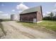 Rustic red barn with a metal roof and gravel road leading up to it, with a silo nearby at 17550 N 200 W, Summitville, IN 46070