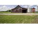 Rustic barn exterior showcasing weathered wood, open entrance, and agricultural storage with grain silos at 17550 N 200 W, Summitville, IN 46070