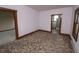 Bedroom features patterned carpet, white walls with wood trim, and a glimpse into an adjacent room at 17550 N 200 W, Summitville, IN 46070