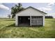 Quaint white garage with an open, weathered door, nestled in a grassy setting with trees in the background at 17550 N 200 W, Summitville, IN 46070
