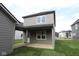 View of the backyard featuring a gray exterior, covered patio, and green lawn perfect for outdoor activities at 1817 Real St, Indianapolis, IN 46240