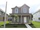 Charming two-story home with a covered front porch and well-manicured lawn showcasing curb appeal at 1817 Real St, Indianapolis, IN 46240