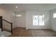Bright, unfinished living area with a staircase and a large window allowing natural light at 1817 Real St, Indianapolis, IN 46240