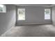 This bedroom features neutral walls, carpet, tray ceiling and three bright windows at 1821 Real St, Indianapolis, IN 46240