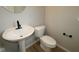Modern powder room features pedestal sink, black faucet, round mirror, and wood-look floor at 1821 Real St, Indianapolis, IN 46240