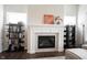 Fireplace with mantel, flanked by shelving and cabinetry in living room with wood floor and neutral walls at 1872 Wellpark Dr, Westfield, IN 46074