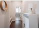 Inviting hallway with hardwood floors, a built-in bench, and view into the laundry room at 1872 Wellpark Dr, Westfield, IN 46074