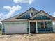 Charming single-story home with a two-car garage under construction with blue sky and clouds at 188 Springfield Xing, Greenfield, IN 46140