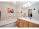 Bathroom with soaking tub, tile surround, and a light wood vanity at 2508 W Sun Valley Pkwy, Muncie, IN 47303