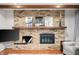 Close-up of the brick fireplace with wood mantel, decorative logs, and mounted television at 2508 W Sun Valley Pkwy, Muncie, IN 47303