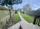 The backyard with a concrete path surrounded by a worn wooden fence and green grass at 2918 Ruckle St, Indianapolis, IN 46205