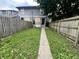 Backyard with a concrete path, wood fence, and some untamed vegetation and foliage at 2918 Ruckle St, Indianapolis, IN 46205