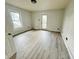 Sunlit bedroom featuring light gray walls, new flooring and a door to the exterior at 2918 Ruckle St, Indianapolis, IN 46205