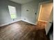 Bedroom with hardwood floors and a window, next to an open doorway at 2918 Ruckle St, Indianapolis, IN 46205