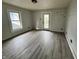 This bedroom has gray laminate floors, a window, a ceiling light, and a door leading to the outside at 2918 Ruckle St, Indianapolis, IN 46205