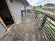 This house features a deck with wooden floors and a metal railing. The house is gray with black trim at 2918 Ruckle St, Indianapolis, IN 46205