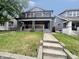 Two-story home featuring a spacious yard, classic architectural details, and covered front porch at 2918 Ruckle St, Indianapolis, IN 46205