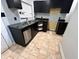 Kitchen with dark cabinets, granite countertops, stainless steel dishwasher, and tiled flooring at 2918 Ruckle St, Indianapolis, IN 46205
