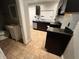 Kitchen with dark cabinetry, stainless steel appliances, and tiled flooring at 2918 Ruckle St, Indianapolis, IN 46205